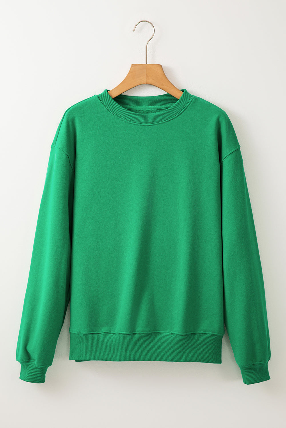green drop shoulder sweatshirt on a hanger showcasing soft terry fabric and relaxed fit