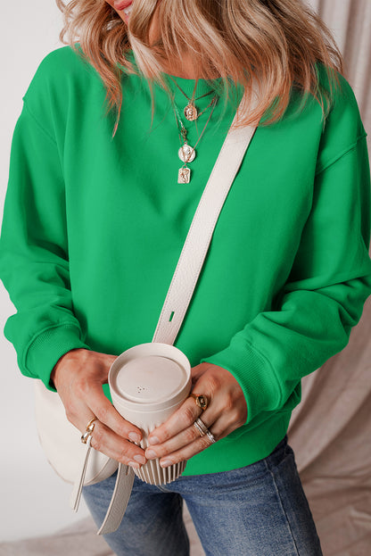 green drop shoulder sweatshirt on a hanger showcasing soft terry fabric and relaxed fit