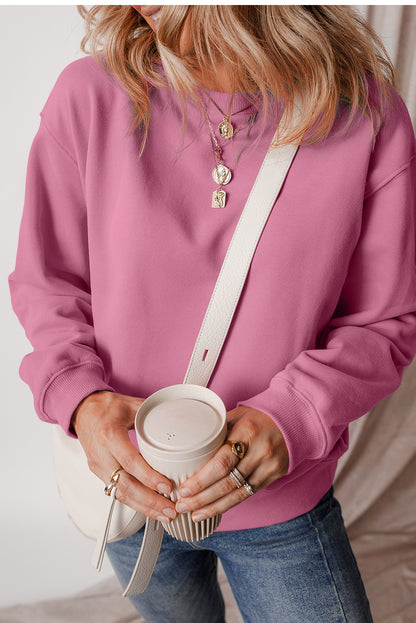 pink drop shoulder sweatshirt on a hanger showcasing soft terry fabric and relaxed fit