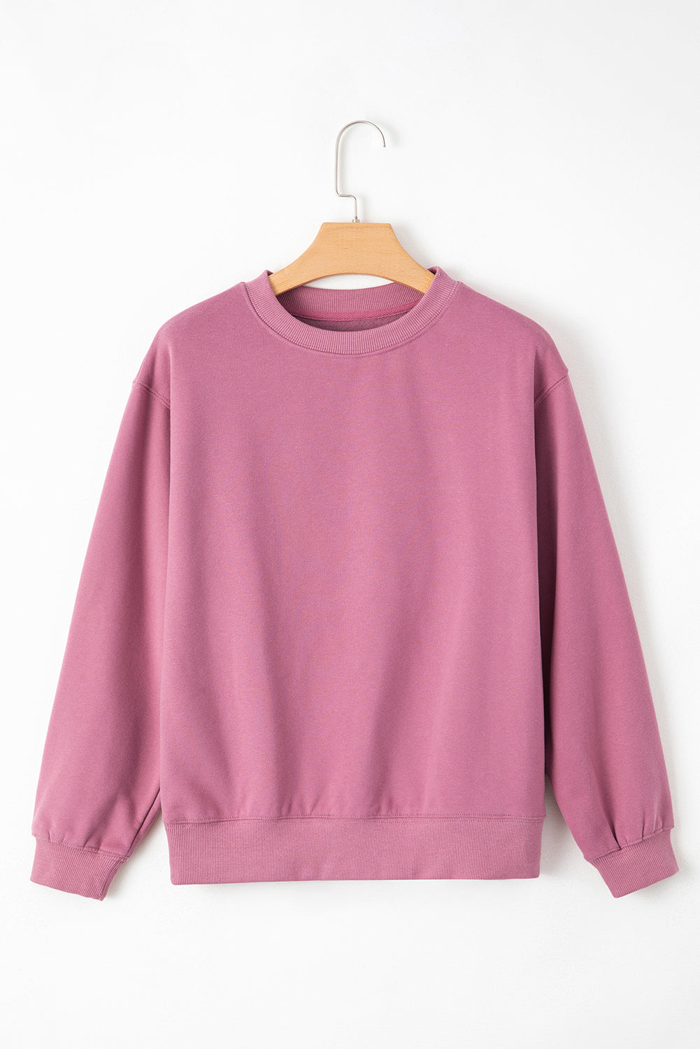 pink drop shoulder sweatshirt on a hanger showcasing soft terry fabric and relaxed fit
