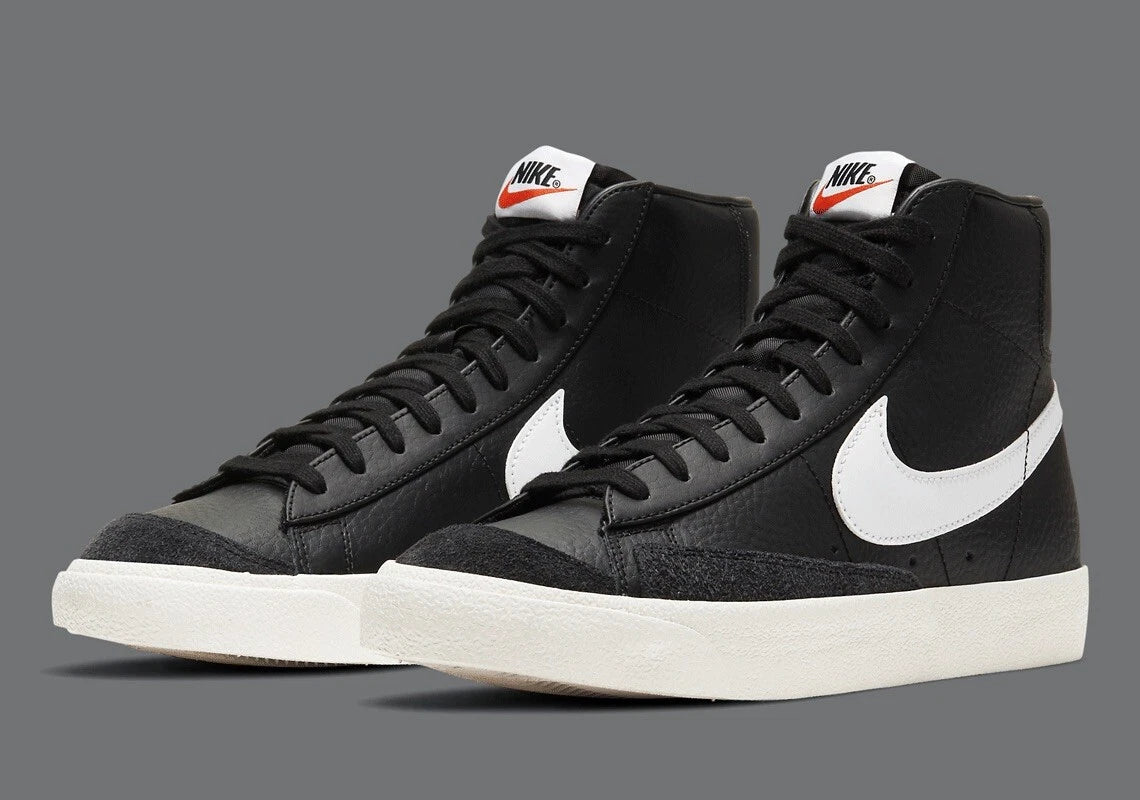 Black high-top sneakers with white Nike logo on a gray background